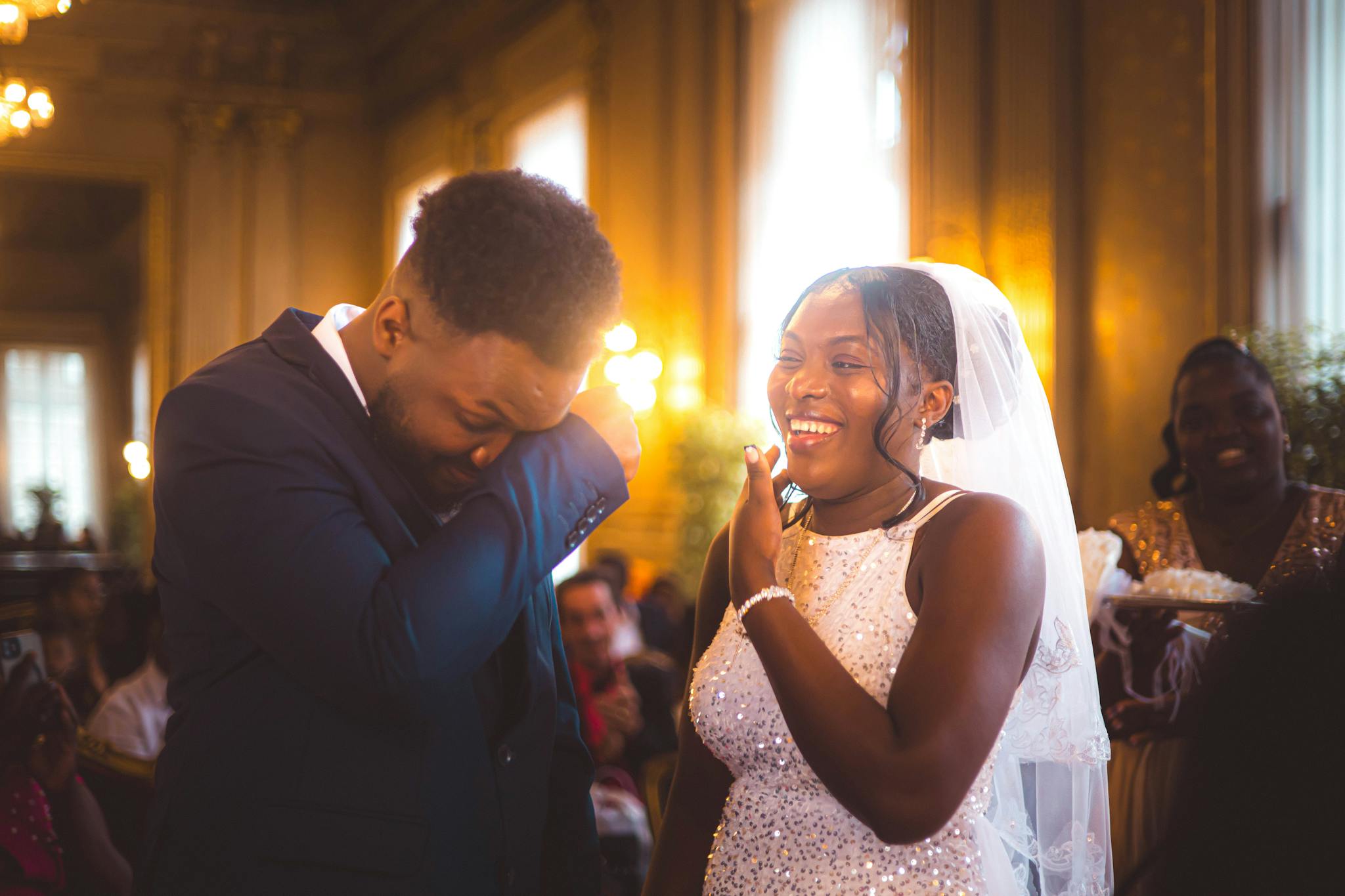 A heartfelt moment at a wedding ceremony as the bride and groom share emotions in a beautifully ornate hall.